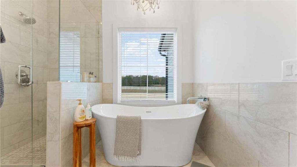 28 Ravenfield Road Taylorsville, GA 30178 - Photo 19 of 38 a white bath tub sitting in a bathroom next to a window