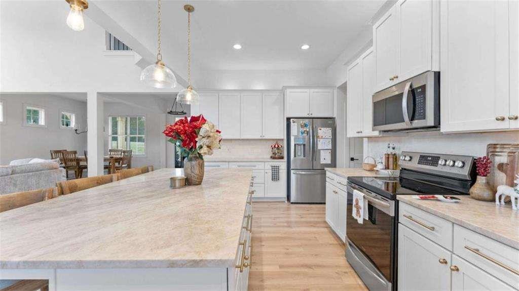 28 Ravenfield Road Taylorsville, GA 30178 - Photo 9 of 38 a kitchen with stainless steel appliances kitchen island granite countertop a refrigerator a stove top oven a sink dishwasher and white cabinets with wooden floor