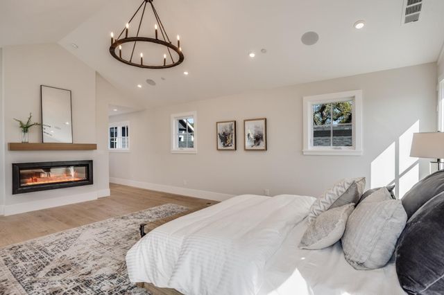a view of a house with a yard plants and large tree