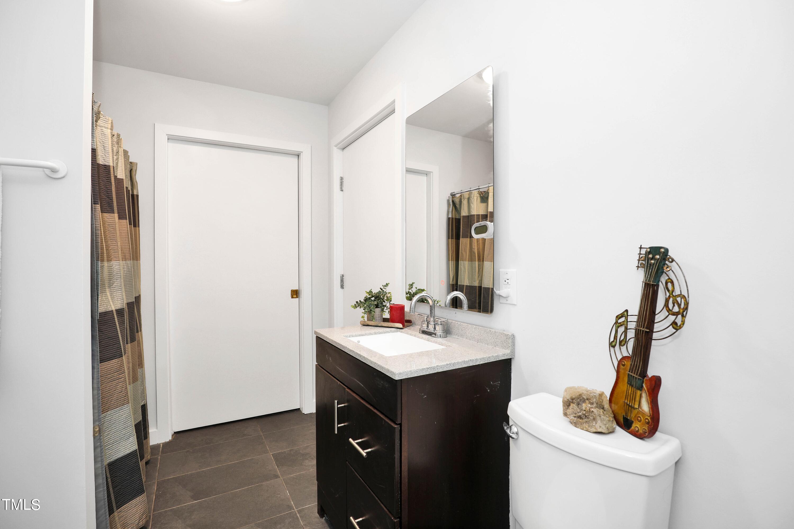 11312 Old Creedmoor Road Raleigh, NC 27613 - Photo 53 of 62 a bathroom with a sink toilet and mirror