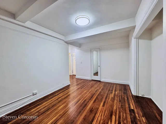 a kitchen with a sink wooden floor and black wooden cabinets