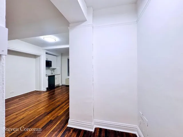 a view of an empty room with wooden floor
