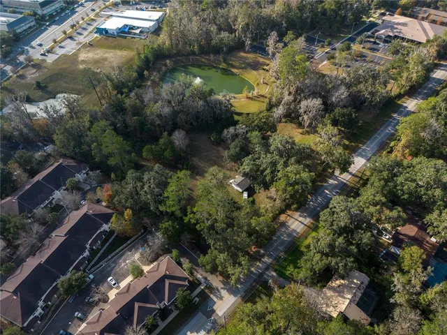an aerial view of residential houses with outdoor space and trees