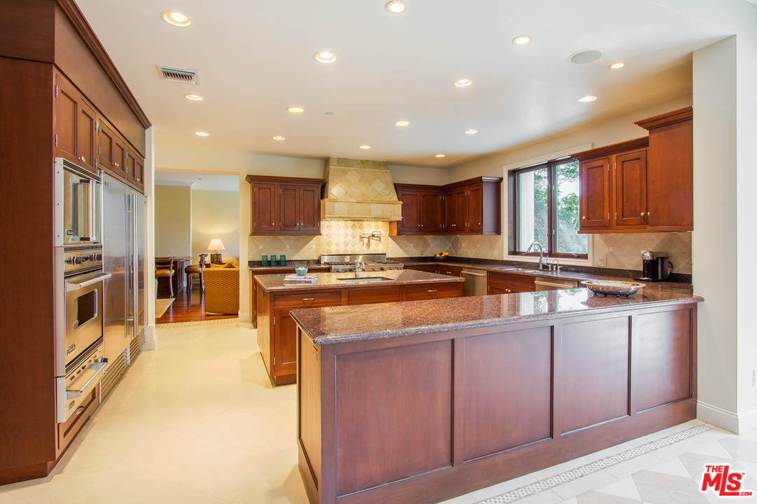 13951 Durham Road Beverly Hills, CA 90210 - Photo 7 of 29 a kitchen with stainless steel appliances granite countertop wooden cabinets a sink and a stove