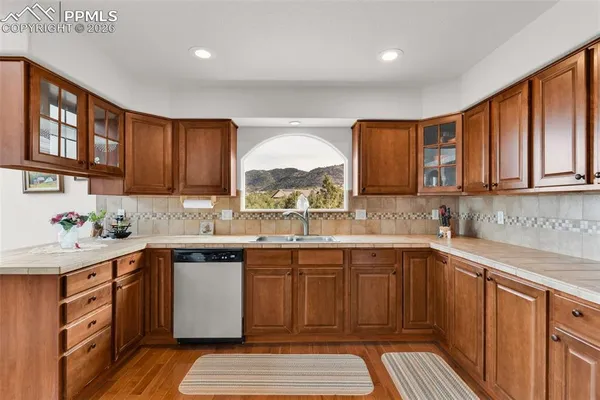 a open kitchen with granite countertop a stove a sink a dining table and chairs