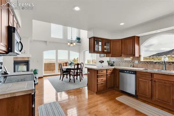 a kitchen with stainless steel appliances granite countertop a stove top oven a sink dishwasher and a microwave oven with large wooden cabinets