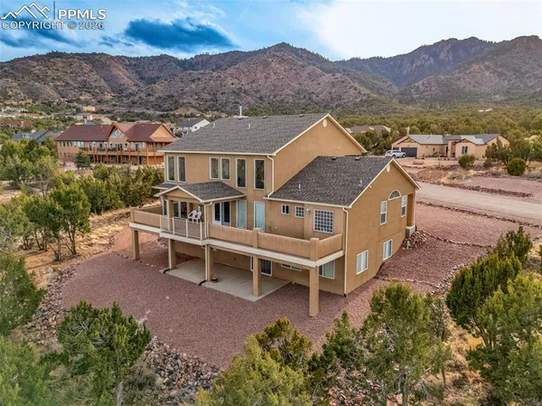 a view of a house with a yard and a mountain view in back