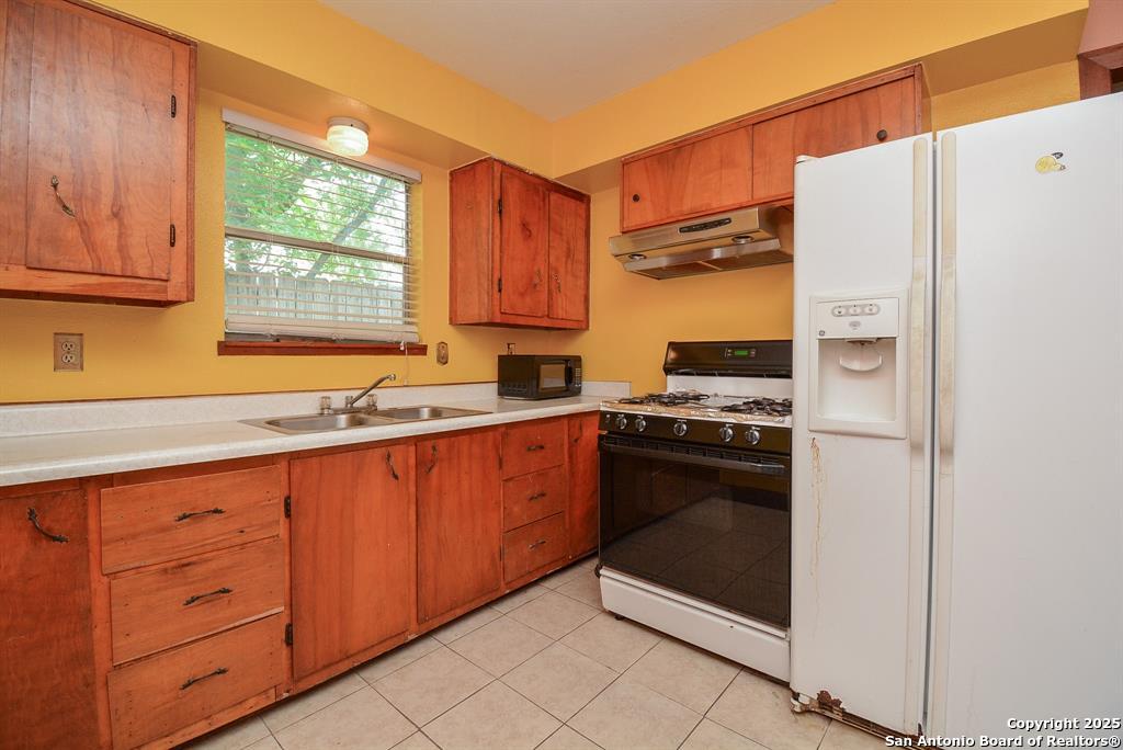 6646 1/2 Lodge Street Houston, TX 77092 - Photo 7 of 14 a kitchen with stainless steel appliances granite countertop a refrigerator and a sink