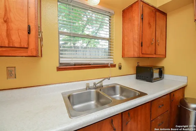 a kitchen with a sink cabinets and a window