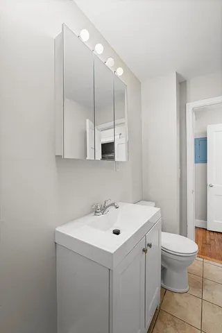 a bathroom with a sink a toilet and a mirror