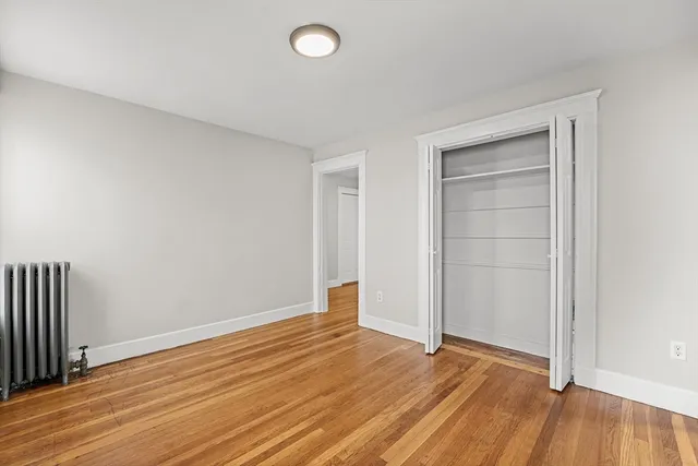 an empty room with wooden floor and closet