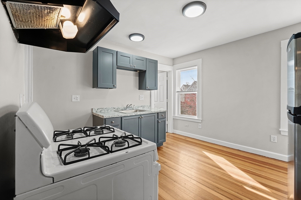 40 Ripley Road, Unit 2 Boston, MA 02124 - Photo 2 of 34 a kitchen with a stove and a wooden floor