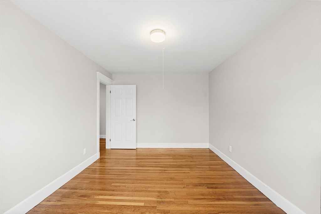 40 Ripley Road, Unit 2 Boston, MA 02124 - Photo 21 of 34 a view of an empty room with wooden floor