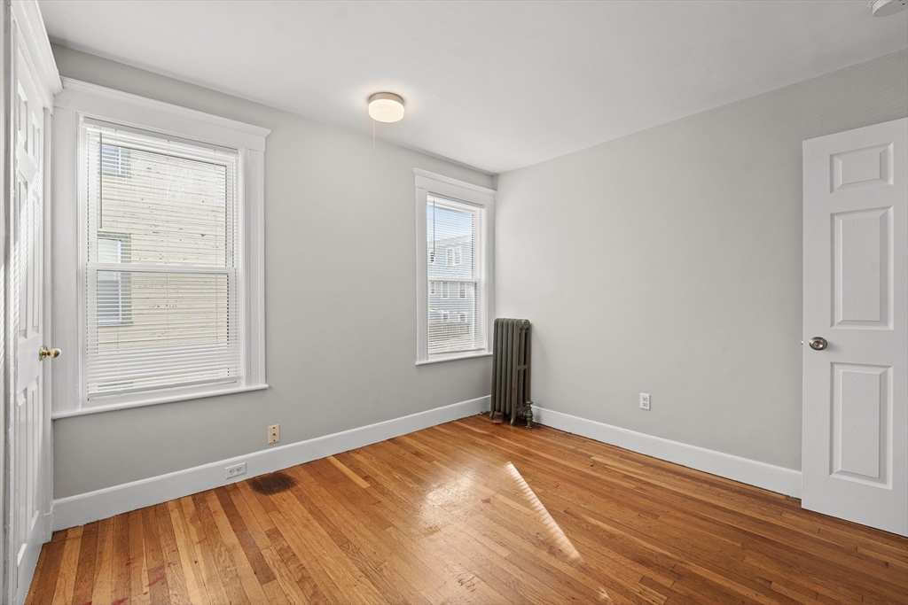 40 Ripley Road, Unit 2 Boston, MA 02124 - Photo 24 of 34 an empty room with wooden floor and windows