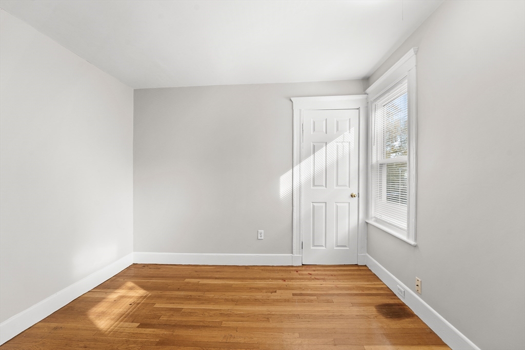 40 Ripley Road, Unit 2 Boston, MA 02124 - Photo 26 of 34 a view of an empty room with wooden floor and a window