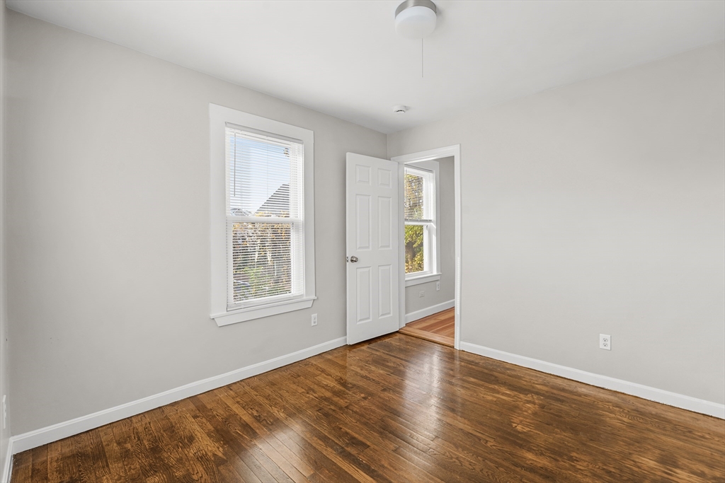 40 Ripley Road, Unit 2 Boston, MA 02124 - Photo 29 of 34 an empty room with wooden floor and windows