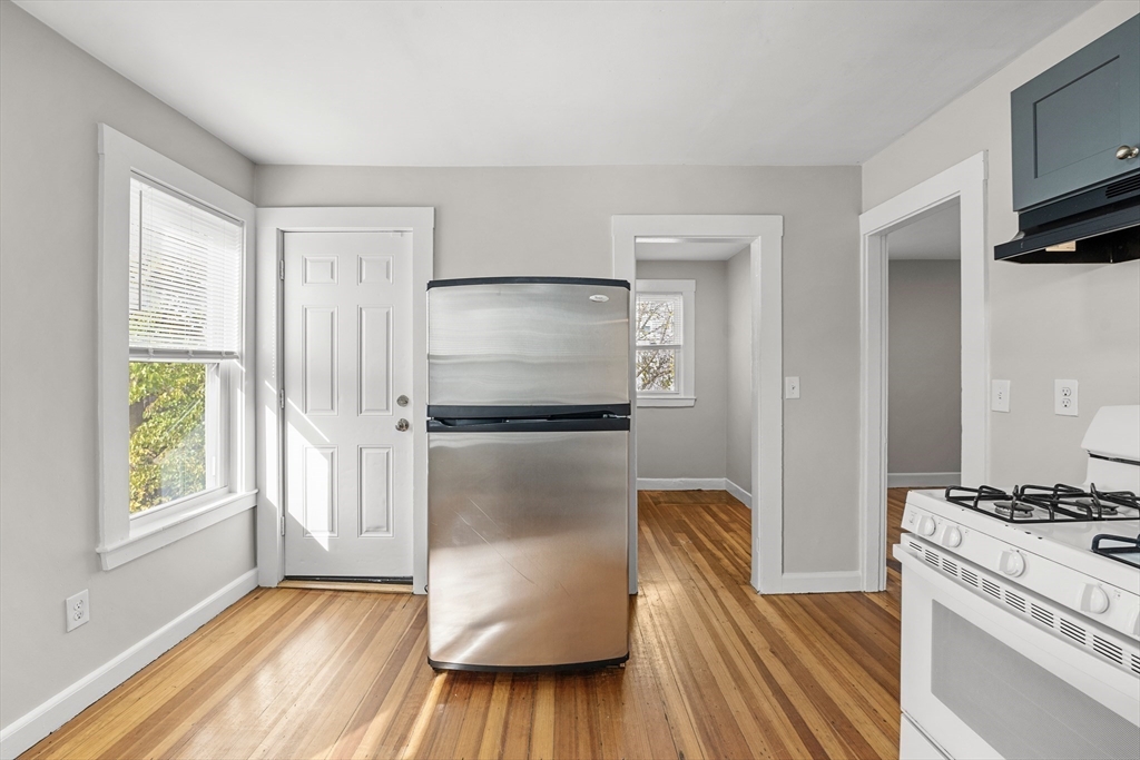 40 Ripley Road, Unit 2 Boston, MA 02124 - Photo 5 of 34 a kitchen with stainless steel appliances granite countertop a refrigerator and a stove