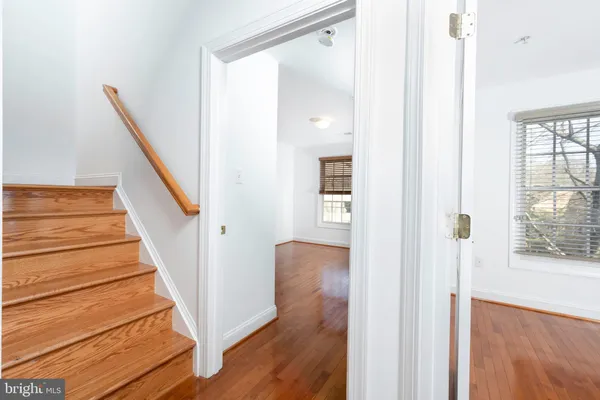 a view of a hallway with wooden floor and staircase