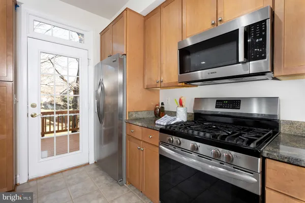 a kitchen with stainless steel appliances granite countertop a stove microwave and refrigerator