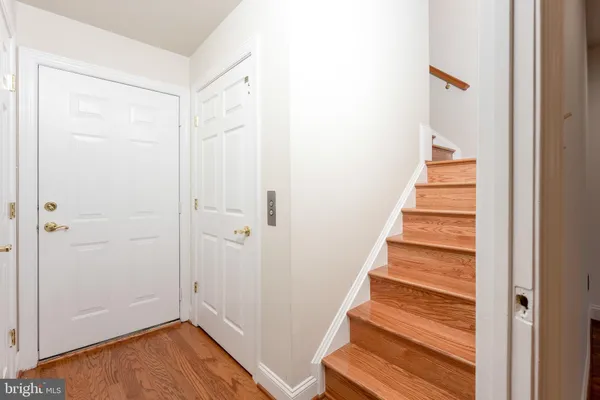 a view of a hallway with wooden floor and entryway