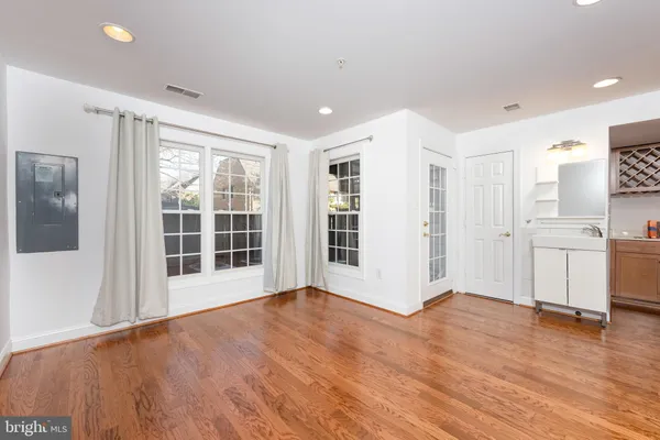 a view of empty room with wooden floor and window