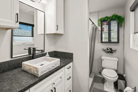 a view of a patio with table and chairs under an umbrella with a small yard