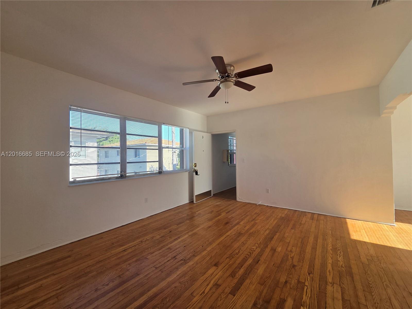 781 Southwest 11th Street, Unit 3 Miami, FL 33129 - Photo 2 of 9 a view of empty room with wooden floor and fan