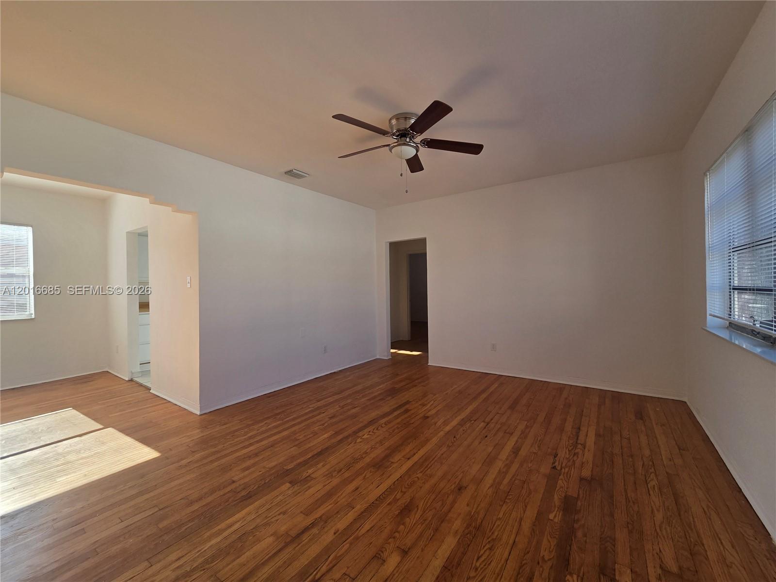 781 Southwest 11th Street, Unit 3 Miami, FL 33129 - Photo 3 of 9 a view of empty room with wooden floor and ceiling fan