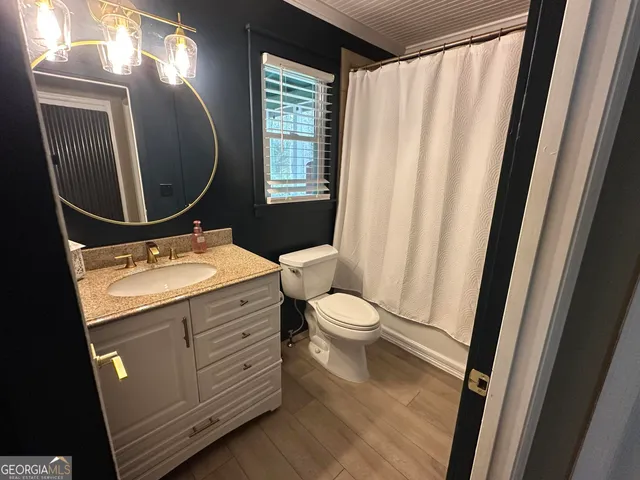 a bathroom with a toilet a sink a mirror a vanity and window