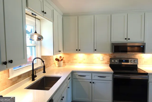 a kitchen with granite countertop a sink stainless steel appliances and cabinets