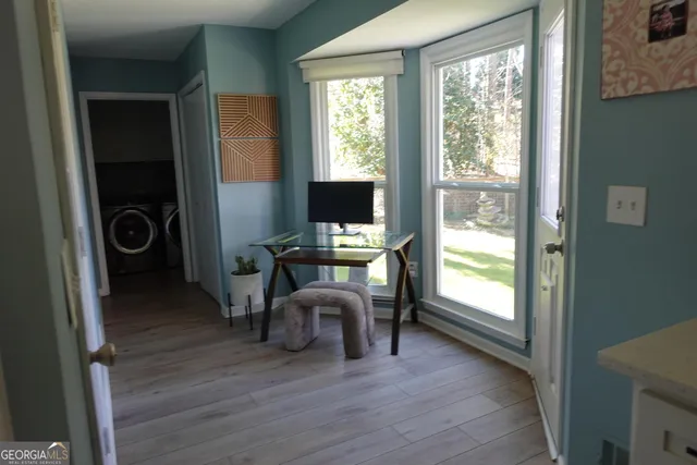 a view of a workspace with furniture and a window