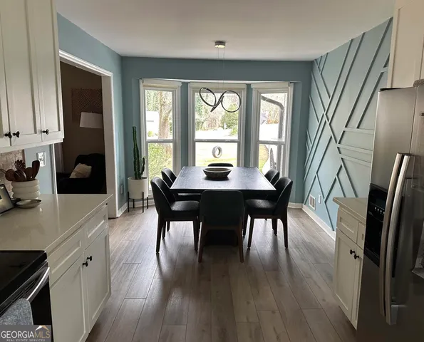 a dining room with furniture and wooden floor