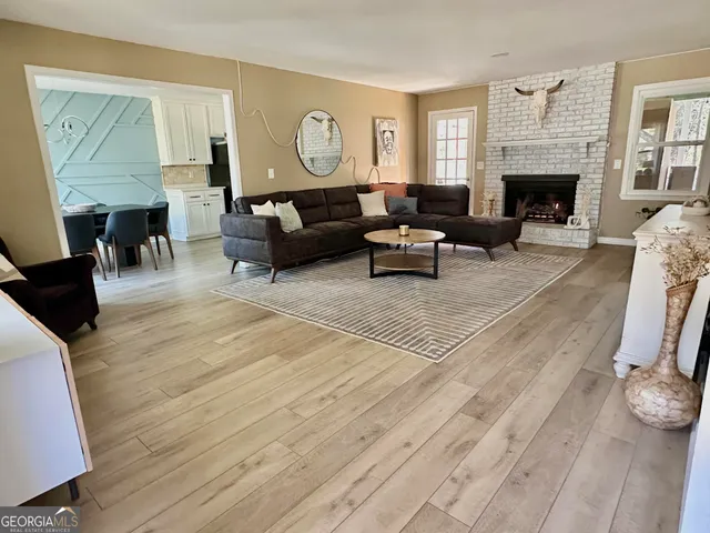 a living room with furniture a fireplace and a large mirror