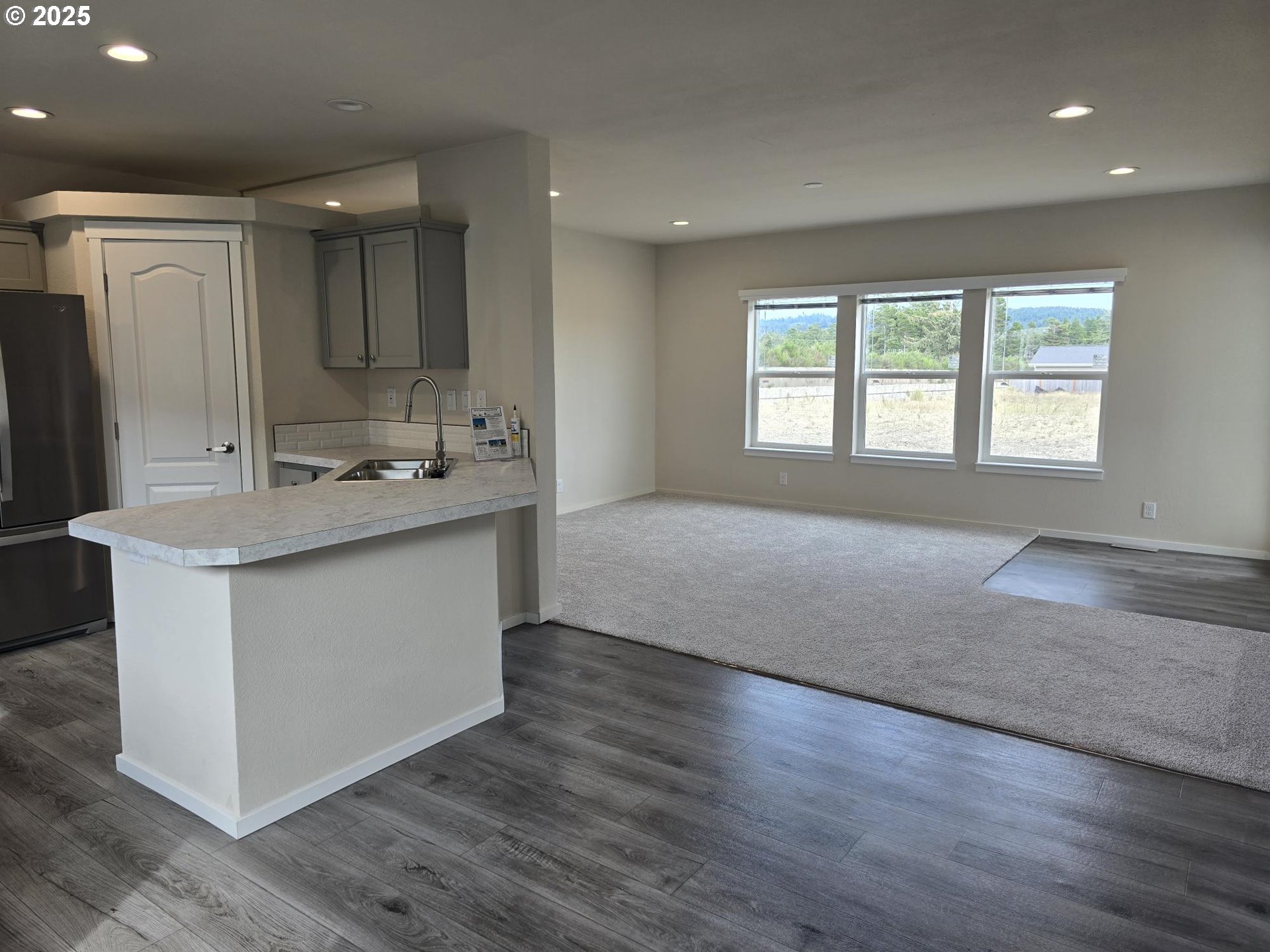 1447 53rd Street Florence, OR 97439 - Photo 9 of 25 a hall with cabinets and wooden floor