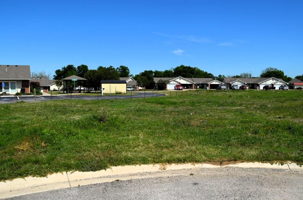 206 Preston Road Mabank, TX 75147 - Photo 4 of 5 a car parked in the grass with a view of building in the background