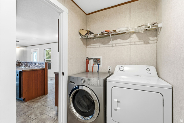 2875 North Hill Field Road, Unit 62 Layton, UT 84041 - Photo 26 of 34 Dedicated laundry area featuring a wire storage shelf, textured wall panels, and wood-trim accents