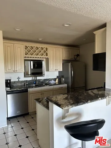 a kitchen with stainless steel appliances granite countertop a sink and a stove