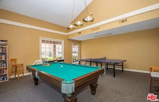 a room with pool table and windows