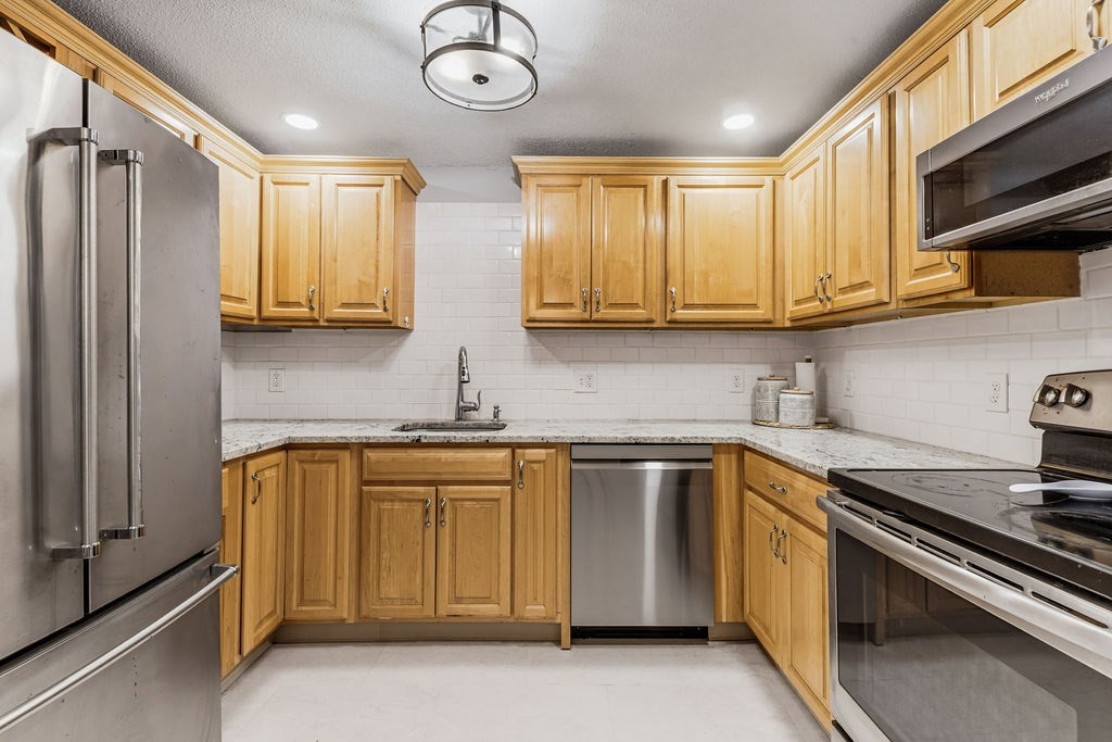 10 Erick Road, Unit 42 Mansfield, MA 02048 - Photo 14 of 33 a kitchen with stainless steel appliances granite countertop a sink a stove and a refrigerator