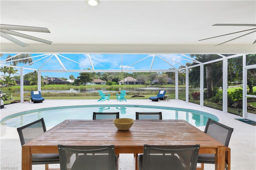 2218 Kings Lake Boulevard Naples, FL 34112 - Photo 13 of 50 a outdoor dining space with furniture and umbrella