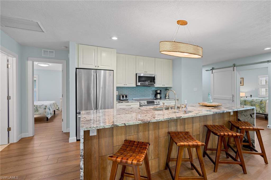 2218 Kings Lake Boulevard Naples, FL 34112 - Photo 14 of 50 a kitchen with stainless steel appliances granite countertop a stove top oven a sink refrigerator and cabinets