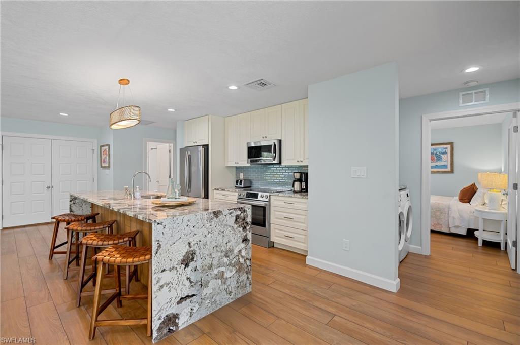 2218 Kings Lake Boulevard Naples, FL 34112 - Photo 15 of 50 a view of a dining room with furniture and wooden floor