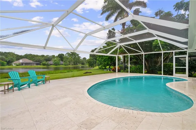 a view of a swimming pool with a patio and a yard