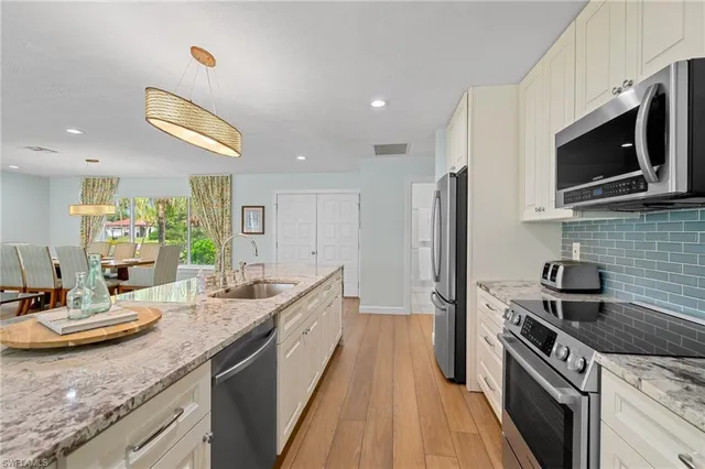 a kitchen with stainless steel appliances granite countertop a sink and a stove