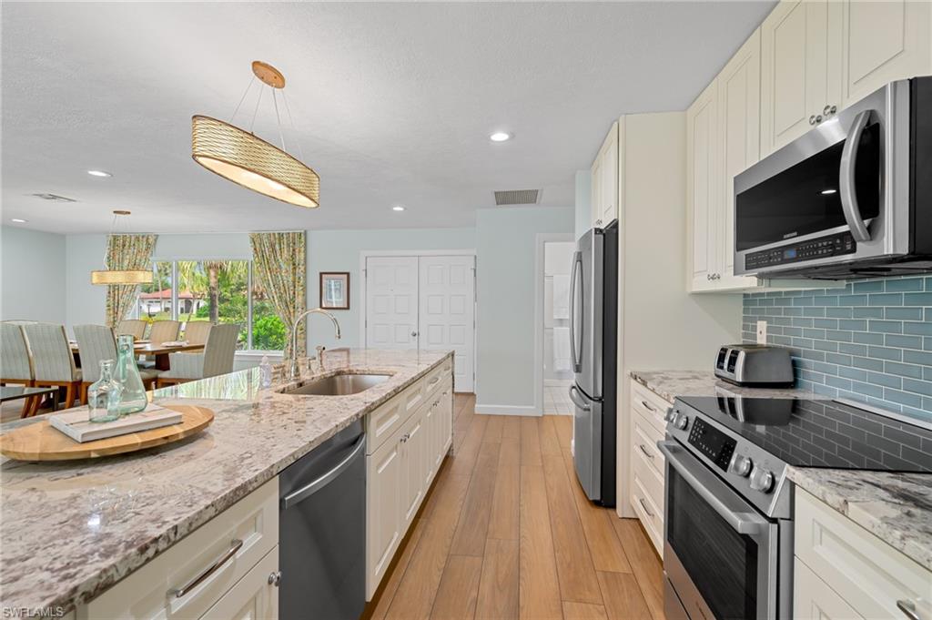 2218 Kings Lake Boulevard Naples, FL 34112 - Photo 17 of 50 a kitchen with stainless steel appliances granite countertop a sink and a stove