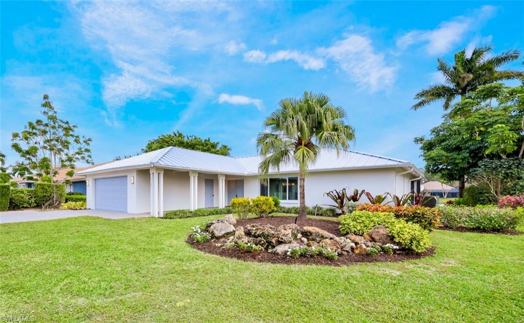 2218 Kings Lake Boulevard Naples, FL 34112 - Photo 2 of 50 a front view of a house with a garden