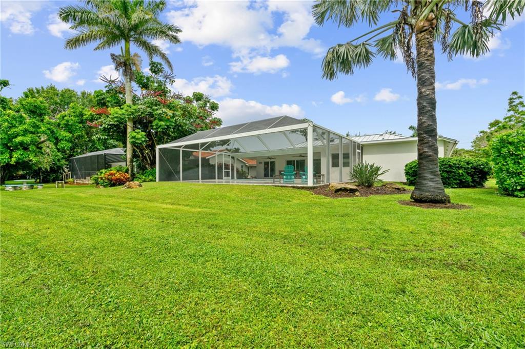2218 Kings Lake Boulevard Naples, FL 34112 - Photo 22 of 50 a view of a house with a yard and palm trees