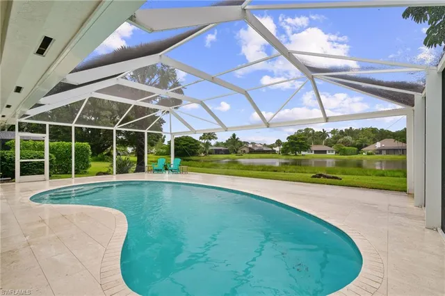 a view of a swimming pool with a yard in front of it