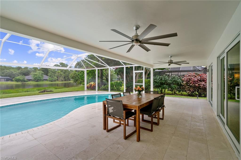 2218 Kings Lake Boulevard Naples, FL 34112 - Photo 34 of 50 a view of a patio with a table chairs and a swimming pool