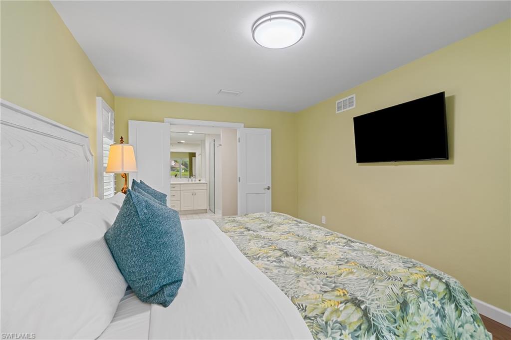 2218 Kings Lake Boulevard Naples, FL 34112 - Photo 44 of 50 a bedroom with a bed and a flat screen tv